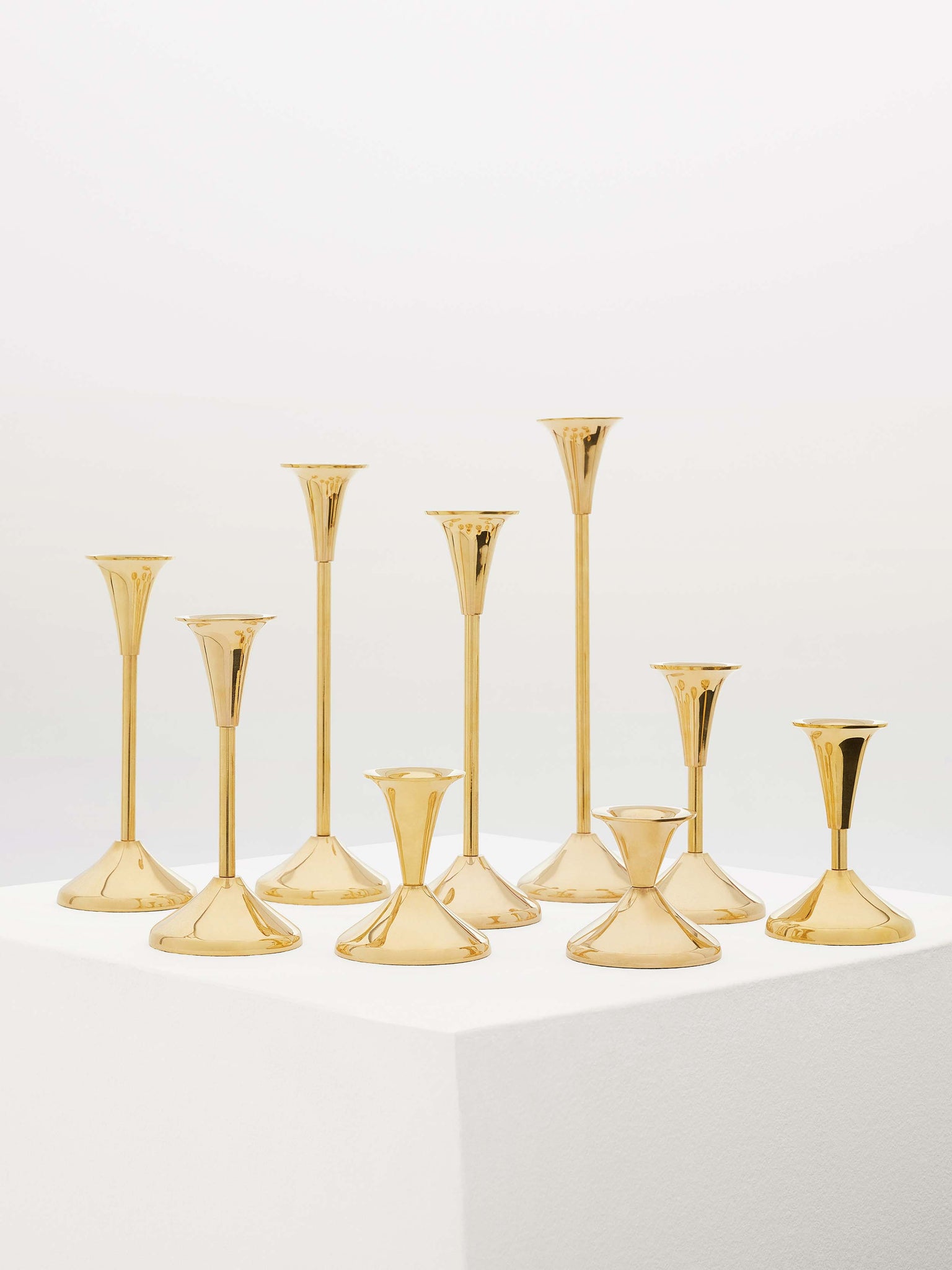 Lot - Pair of brass push up candlesticks with diamond, beehive and bell  standard, marked England, 9 3/4 h; along with a second pair of brass  candlesticks, baluster form standard on square